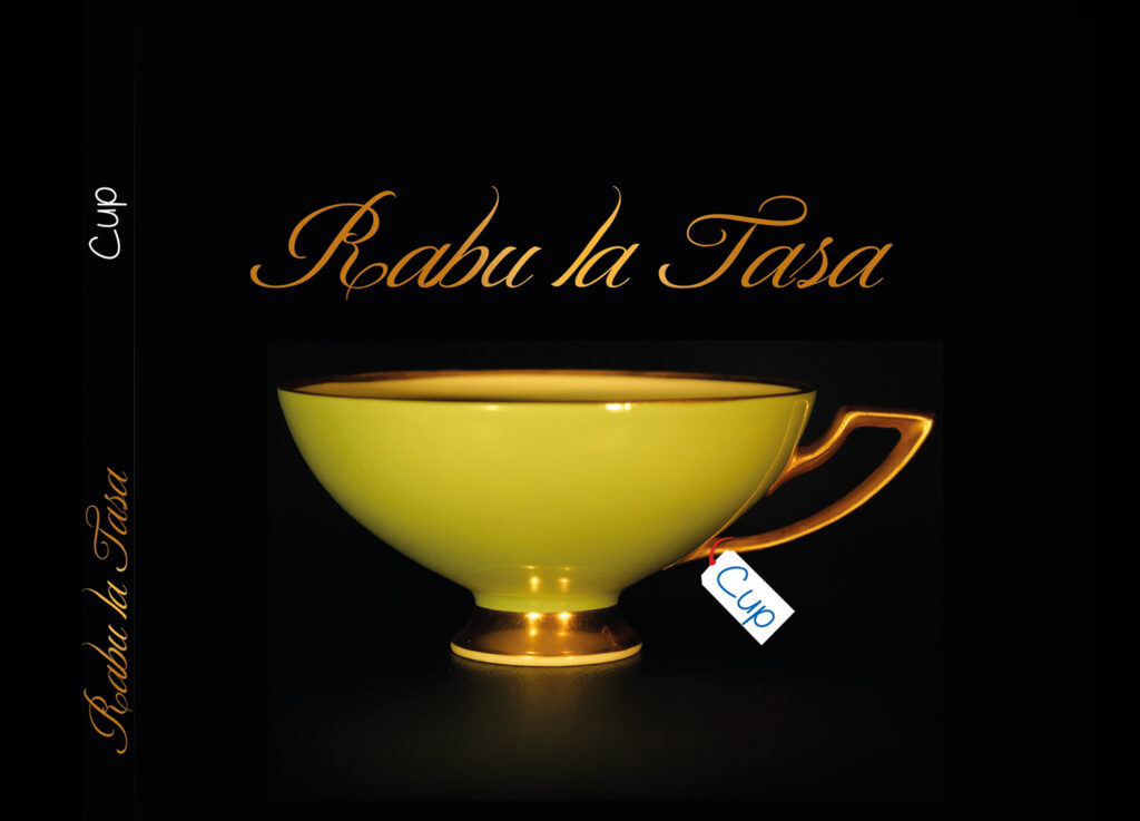 Eine gelb-goldene Antike Tasse auf schwarzem Hintergrund mit goldener Schrift ''Rabu la Tasa''