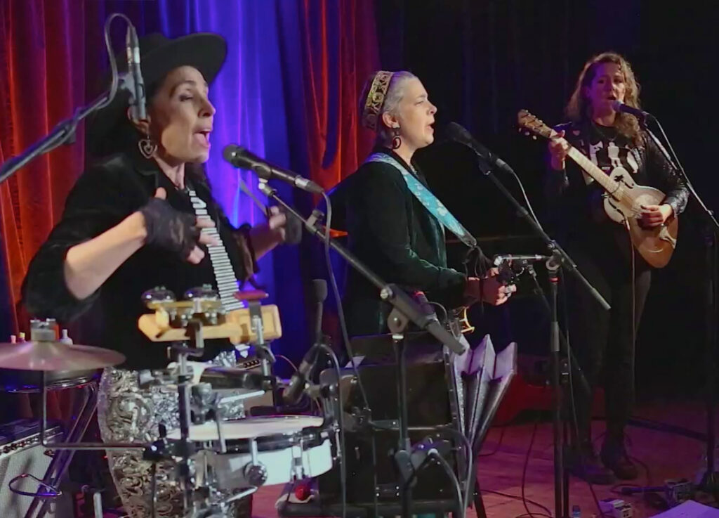 3 Frauen, mittlerem alter, singen und musizieren in einem beleuchtetem Studio